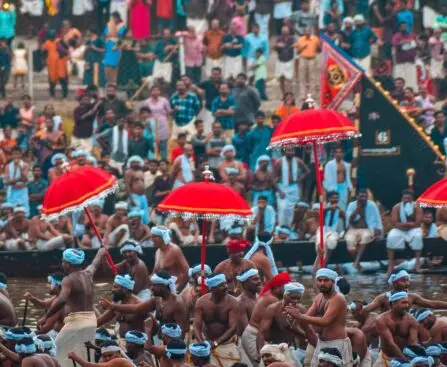Traditional Aranmula boat race with colorful snake boats rowing in unison on the Pampa River, Kerala.