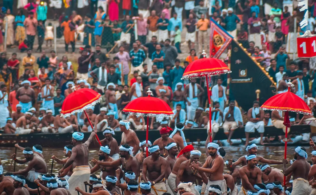 Traditional Aranmula boat race with colorful snake boats rowing in unison on the Pampa River, Kerala.